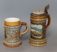 A Mettlach stein decorated with a townscape, a mug decorated with wild boars and a huntsman