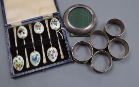 A cased set of six silver and enamel coffee spoons, five silver napkin rings and a sterling