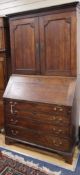 A George III oak bureau cabinet W.100cm