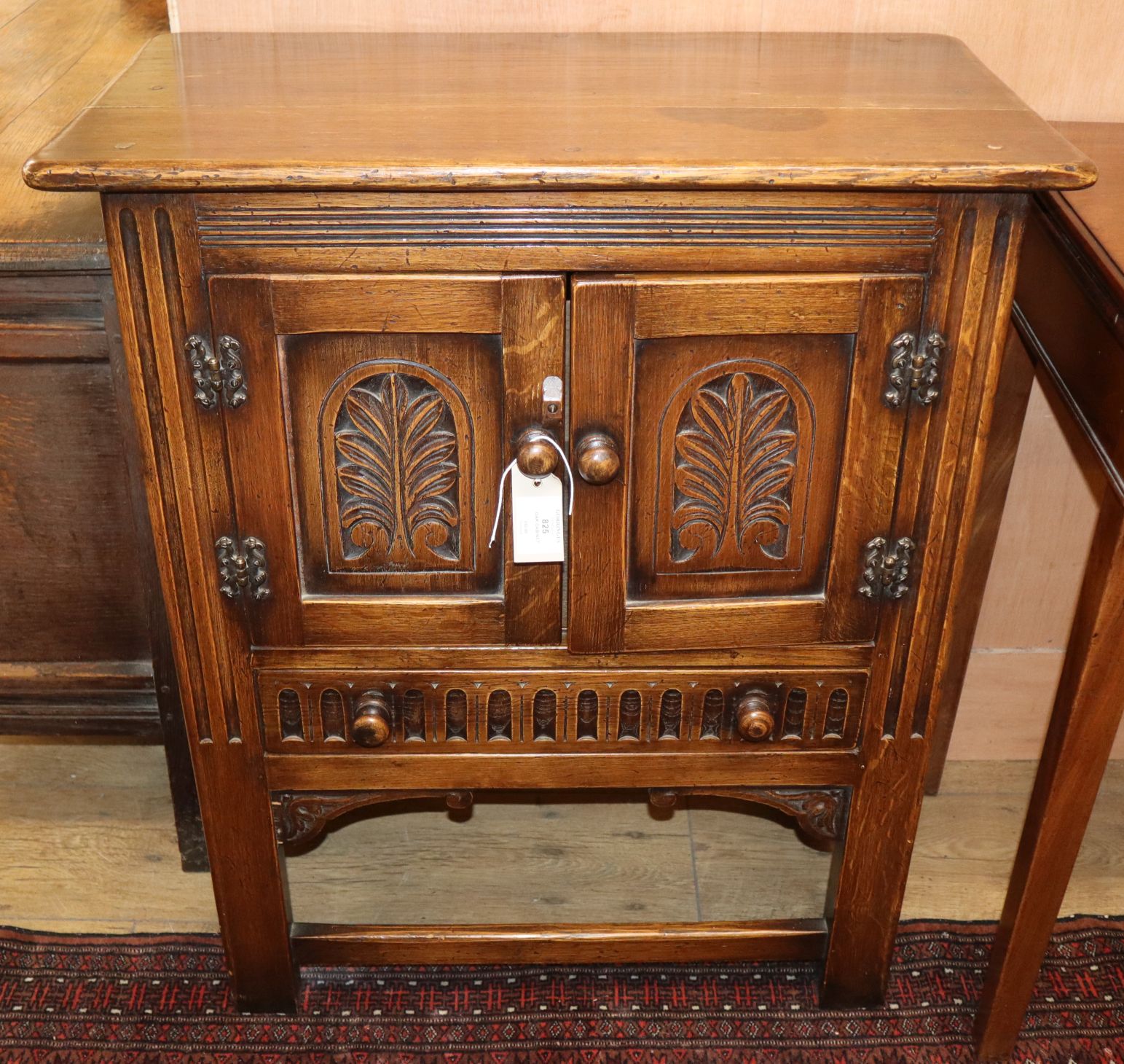 A carved oak two door cabinet W.69cm