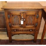 A carved oak two door cabinet W.69cm