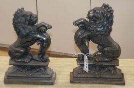 A near pair of cast iron doorstops, decorated as lions 37cm