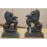 A near pair of cast iron doorstops, decorated as lions 37cm