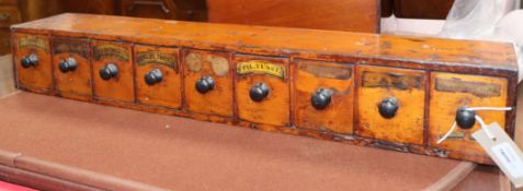 A 19th century apothecary's pine cabinet of small proportions, fitted nine short drawers length