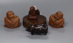 A 19th century Japanese wood netsuke of a seated man together with three carved wood figures 4cm -