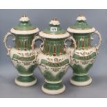 A set of three Victorian style green and gilt lidded ceramic drug vases, with painted labels