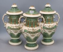 A set of three Victorian style green and gilt lidded ceramic drug vases, with painted labels