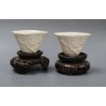 A pair of 18th century Chinese blanc de chine libation cups, wood stands