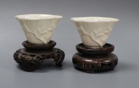 A pair of 18th century Chinese blanc de chine libation cups, wood stands