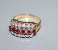 An 18k gold ruby and diamond triple row ring, size S