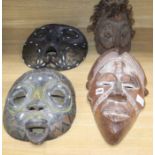 Two Luba bead worked tribal masks, another mask and a helmet mask