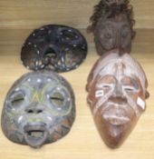 Two Luba bead worked tribal masks, another mask and a helmet mask