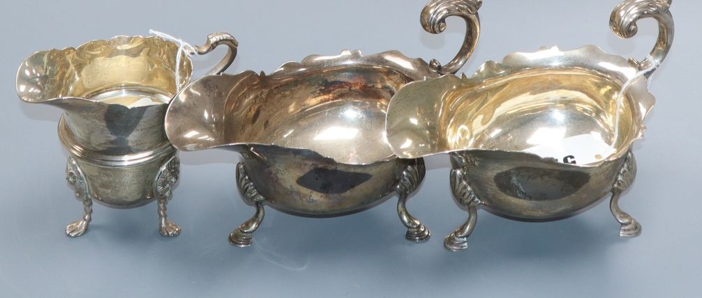 A matched pair of silver cream boats with shaped rims and C-scroll handles, London 1899/1900, 16oz