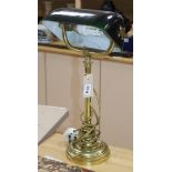 A brass desk lamp with green glass shade