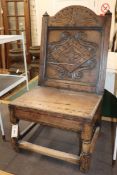 A 17th century carved oak back stool, with lozenge-carved panel