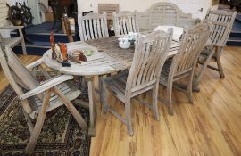 A teak garden table and six chairs Table W.124cm