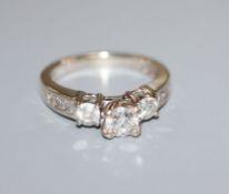 A 14k white gold and diamond dress ring, the central stone approximately 0.50cts, flanked by two 0.