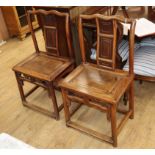 A pair of Chinese elm yoke back chairs