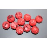 Eleven Chinese carved coral beads, diameter 1.8cm
