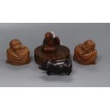 A 19th century Japanese wood netsuke of a seated man together with three carved wood figures 4cm -