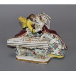 A Sitzendorf porcelain group of amorous lovers seated at a spinet height 11cm