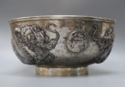 A late 19th/early 20th century Chinese Export white metal bowl, embossed with two dragons chasing