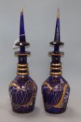 A pair of blue glass decanters with steeple shaped stoppers height 49cm