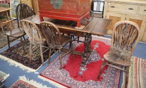 A beech extending dining table and nine wheel back chairs L.167cm fully extended