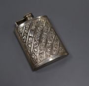 An embossed white metal hip flask inscribed 'sterling silver', 11.6cm.