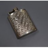 An embossed white metal hip flask inscribed 'sterling silver', 11.6cm.