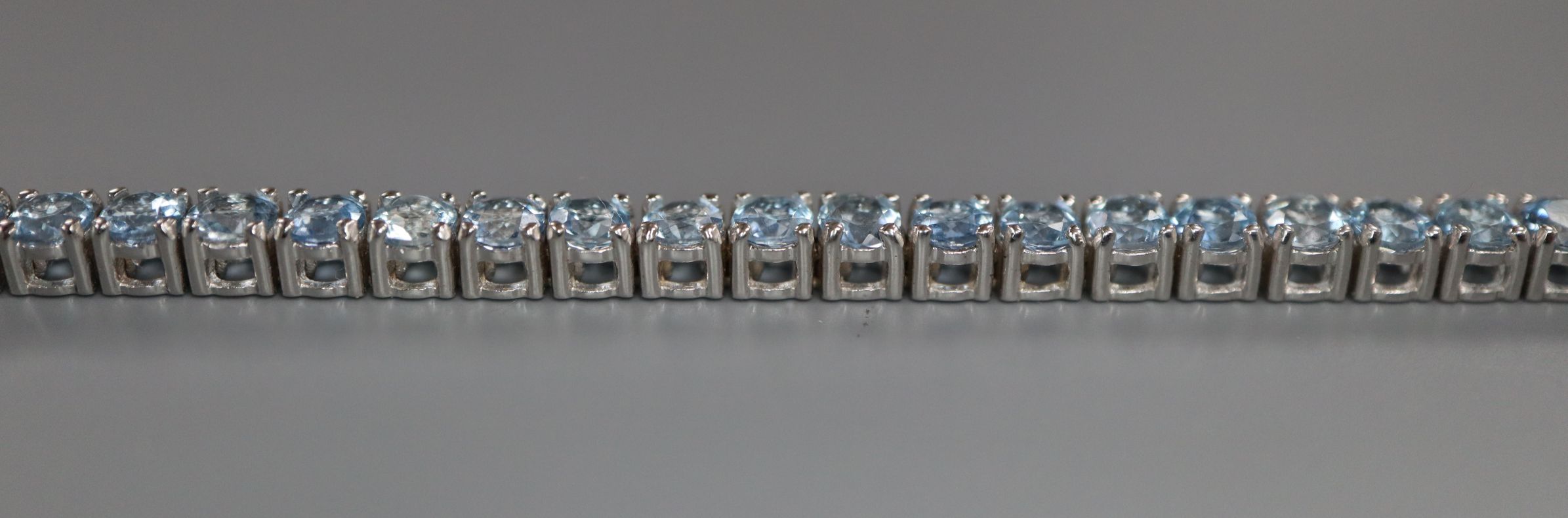 A 750 white metal and aquamarine set line bracelet, 18.2cm. - Image 2 of 4