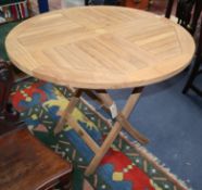 A modern circular teak folding garden table W.90cm