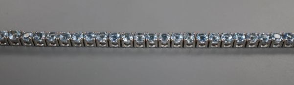 A 750 white metal and aquamarine set line bracelet, 18.2cm.
