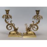 A pair of bronze candlesticks modelled as recumbent deer (lacking glass lustres) height 28cm