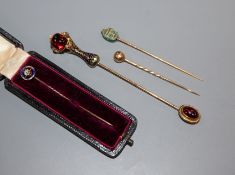 An Edwardian diamond and blue enamel set stick pin and three other stick pins including scarab and