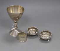 A pair of Victorian silver bun salts, a silver napkin ring and a modern silver goblet.