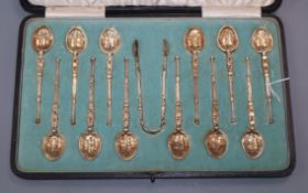 A cased set of 12 silver gilt coffee spoons, Elkington & Co, 1906/7, with similar tongs, Edward