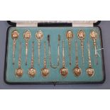 A cased set of 12 silver gilt coffee spoons, Elkington & Co, 1906/7, with similar tongs, Edward