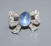 A plat, cabochon star sapphire and diamond set ribbon bow dress ring, possibly adapted from a
