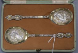 A cased pair of Edwardian ornate parcel gilt silver serving spoons, Robert Stebbings, London 1902,