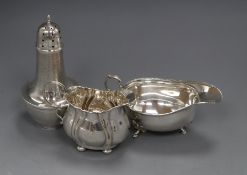 An Edwardian silver cream jug, a later silver sauceboat and silver sugar caster.
