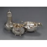 An Edwardian silver cream jug, a later silver sauceboat and silver sugar caster.