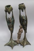 A pair of cast bronze candlesticks and another similar figure