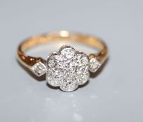 A mid 20th century 18ct, plat and diamond flower head cluster ring, size J.