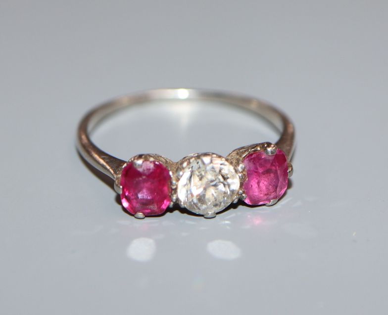 A white metal, ruby and diamond three stone ring, (shank cut).