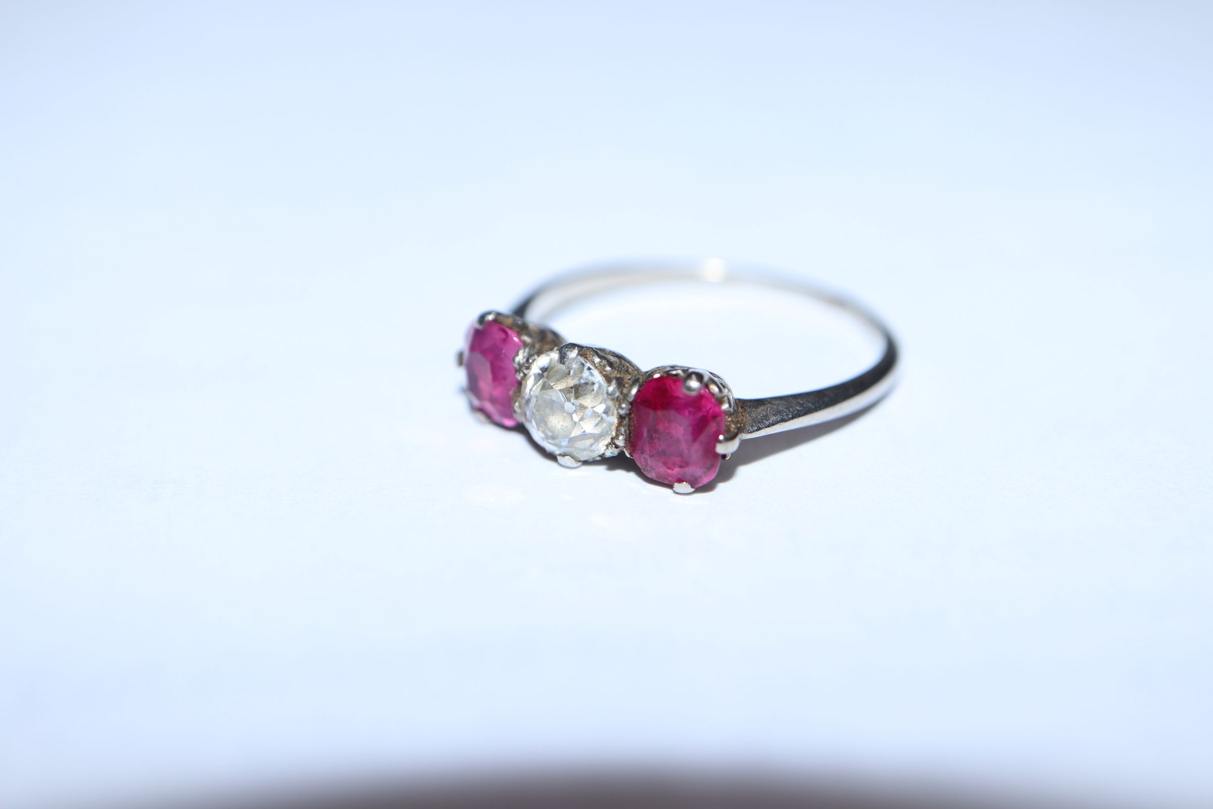 A white metal, ruby and diamond three stone ring, (shank cut). - Image 5 of 7