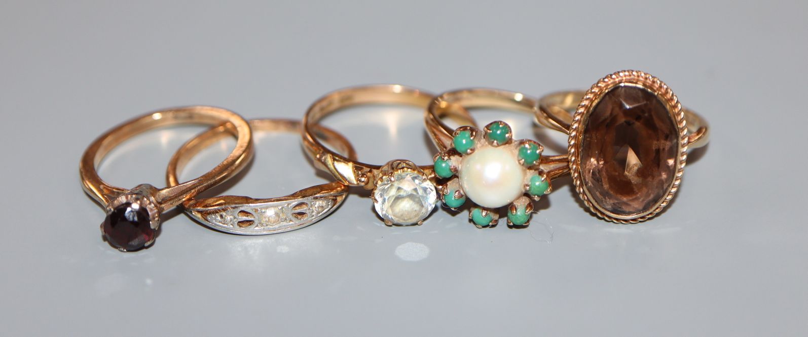 Five assorted gem set rings including 9ct and 14k.