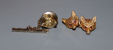 A single 9ct gold cufflink modelled as a pair of fox masks with ruby-set eyes and a 14k single fox