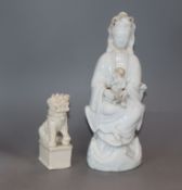 A Chinese blanc de chine group of Guanyin and a child and a Kangxi blanc de chine lion tallest 25cm