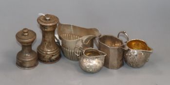 Four assorted silver/white metal cream jugs including late Victorian and two silver mounted pepper